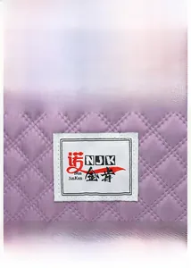 Close-up of purple quilted Oxford fabric texture and woven brand label on the bag