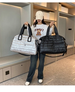 Détail de sacs fourre-tout matelassés en argent et noir avec bandoulière réglable