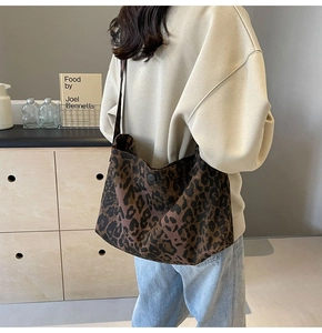 Borsa a tracolla alla moda in tela leopardata indossata da modella in ambiente interno