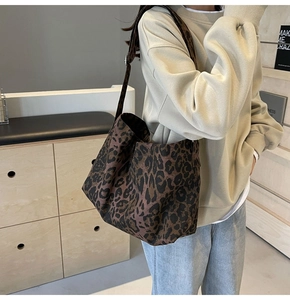 Vista dettagliata della borsa tote in tela leopardata indossata a spalla alla moda