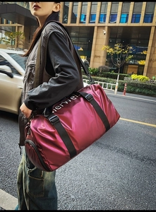 Close-up of wine red oxford travel tote bag with metallic gloss and shoulder strap