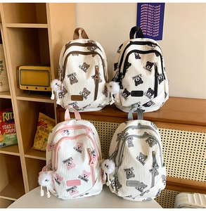 Four colors of bear pattern backpacks displayed on a wooden table with plush pendants