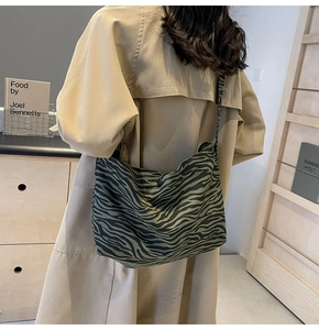 Dettaglio borsa a tracolla in tela con motivo zebra verde e nero sulla spalla