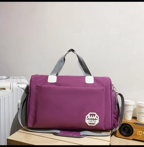 Détail du sac de voyage violet en oxford avec poignées grises et garniture blanche