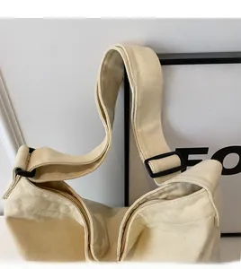 Detail of adjustable canvas strap and zipper closure on a beige minimalist tote bag