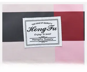 Gros plan sur le tissu oxford à carreaux rose et gris avec étiquette de marque tissée