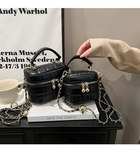 Detail of black quilted square chain bags in large and small sizes with metal ball zipper