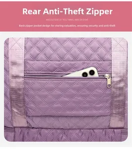 Detail of rear anti-theft zipper pocket on purple quilted nylon travel bag with smartphone