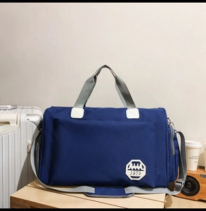 Détail d'un sac de voyage bleu en tissu Oxford avec poignées grises et écusson 1979