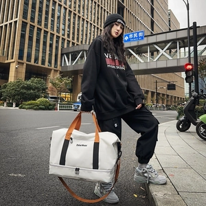 Große beige Oxford-Reisetasche mit orangen Tragegurten und separatem Schuhfach am Boden