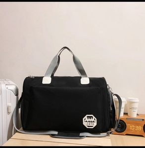 Détail du sac de voyage Oxford noir avec écusson 1979 sur un bureau en bois