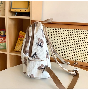 Detail view of the quilted backpack side pocket and cute bear pattern on nylon fabric