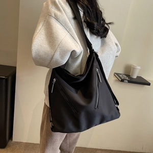 Large capacity black nylon tote bag with functional zippers shown from a side perspective