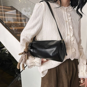 Minimalist black cylinder shoulder bag for women with a cute fabric bunny charm