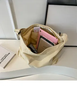 Interior view of off-white canvas tote bag showing large capacity with zipper pocket
