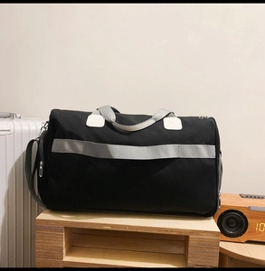Détail du sac de voyage noir en oxford montrant la poche zippée latérale et les sangles