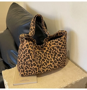 Dettaglio della borsa tote in tela leopardata con fibbia regolabile e tracolla larga