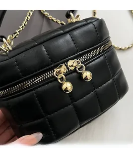 Detail of smooth gold-tone dual zippers and quilted black leather texture on mini bucket bag