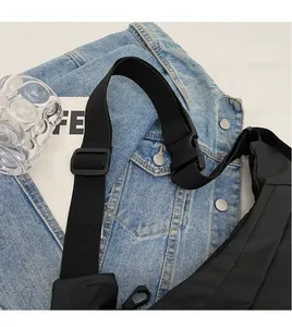 Close-up of adjustable wide nylon shoulder strap and quick-release buckle on a black bag