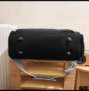 Détail du sac de voyage noir avec picots de protection et bandoulière grise réglable
