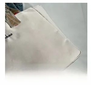 Dettaglio macro del tessuto in tela beige con ricamo e cinturino stampato a colori