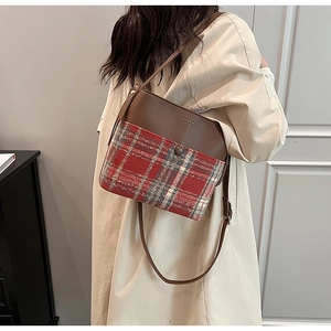 Close-up of vintage plaid wool and brown leather shoulder bag with fashion lettering