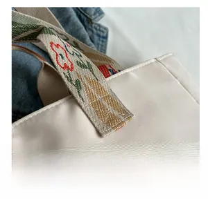 Dettaglio della borsa tote in nylon bianco sporco con manici jacquard floreali