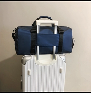 Detail of navy oxford travel bag showing the trolley sleeve sliding over luggage handle