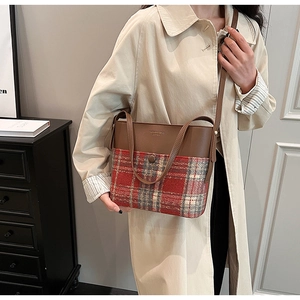 Close-up of retro plaid wool bag with premium brown leather stitching and embossed text