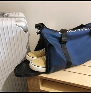 Blue oxford tote travel bag showing a functional side shoe compartment on a suitcase