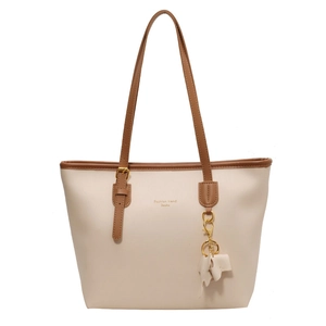 Minimalist cream tote bag with brown straps and cute elephant charm for daily commute
