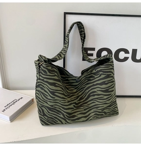 Dettaglio della grande borsa tote in tela con motivo zebra verde e chiusura a scatto