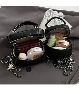 Close-up of black quilted mini bucket bag with leather chain strap and metal charm