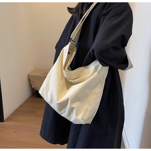 Detail of cream canvas hobo bag showing adjustable shoulder strap and texture