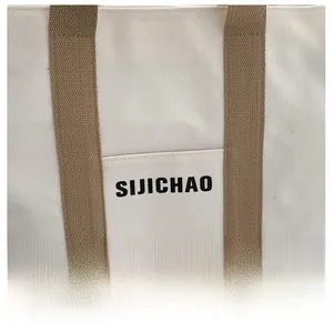 Detail of minimalist canvas tote bag featuring brown textured strap and SIJICHAO branding