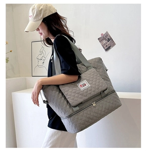 Detail view of grey quilted oxford tote showing front zipper pocket and reinforced stitching