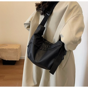 Detailed view of black nylon crescent bag with adjustable wide strap and logo label