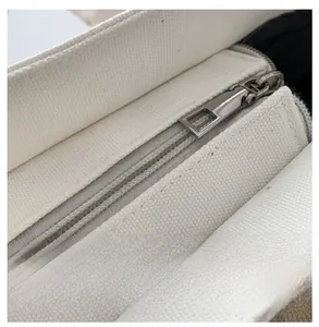 Macro detail of a high-quality smooth silver zipper on a beige canvas tote bag