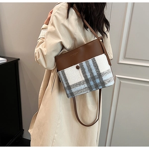 Detail of large capacity bucket bag with brown leather and wool patchwork texture