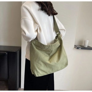 Detail view of olive green canvas tote bag with wide adjustable strap for daily use