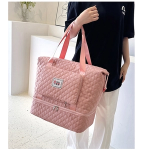 Detail of pink quilted Oxford travel bag showing the water-resistant fabric and shoe compartment