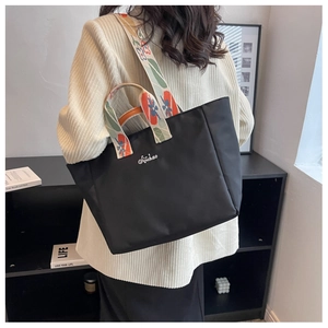 Dettaglio borsa tote in nylon nero con tracolla ricamata a fiori e logo Siyichao