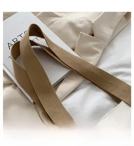 Detail of white canvas tote with sturdy brown woven strap and elegant lifestyle decor