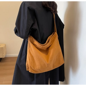 Detail view of large canvas tote bag in ginger brown on model for daily commuting style
