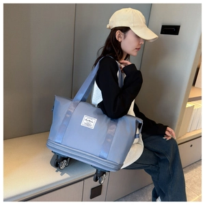 Detail of blue oxford travel bag featuring smooth universal wheels and waterproof fabric