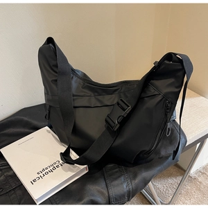 Detail of black nylon crescent bag featuring functional buckle and waterproof fabric texture