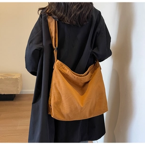 Detailed back view of a caramel canvas tote bag showing the texture and slouchy crescent shape