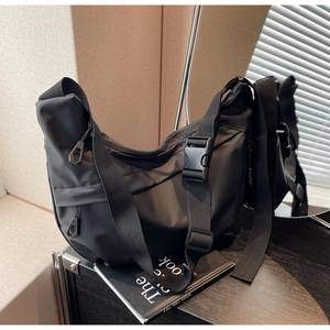 Detail of adjustable strap with large plastic buckle on waterproof nylon crossbody bag