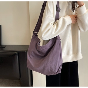 Detail of purple canvas crescent tote showing adjustable strap and large capacity