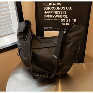Detail of durable black nylon crossbody bag with adjustable wide strap and plastic buckle